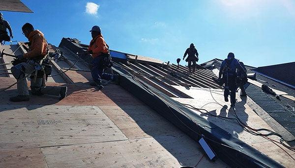 在蓝天下安装屋顶的工人