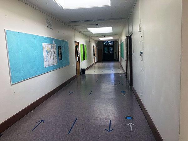 a corridor with a bulletin board on the wall and doors