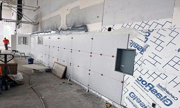 大墙砖正在墙板上的瓷砖垫板上安装