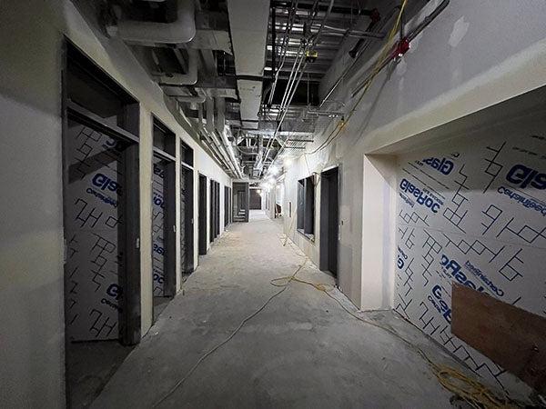 走廊:正在建造的走廊，两边都有大开口, 吊顶结构显示, 用胶带和泥铺墙板