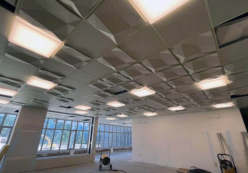 仰望天花板上的灯光和网格状的立体天花板瓷砖
