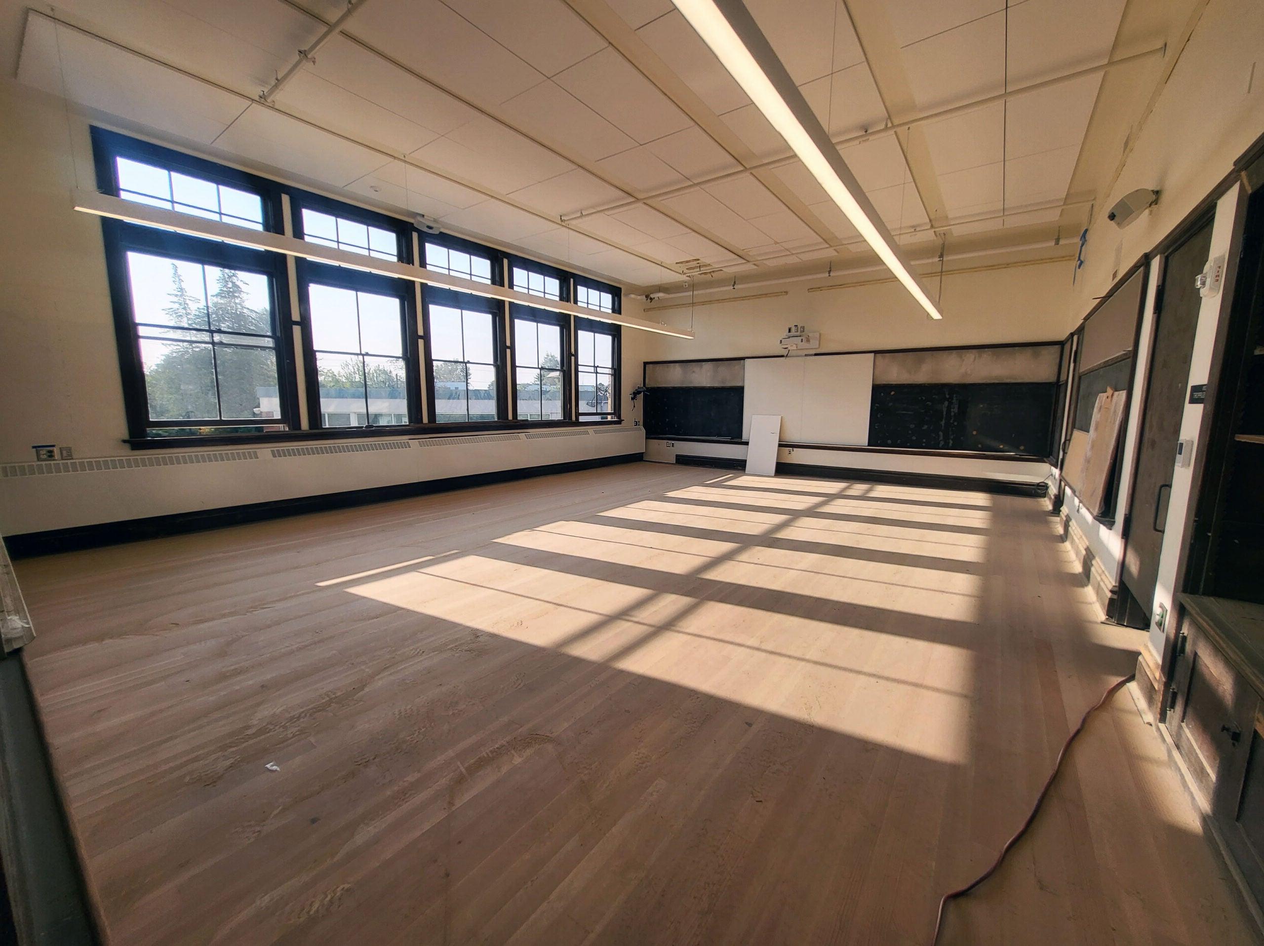 一间有木地板和木框窗的教室