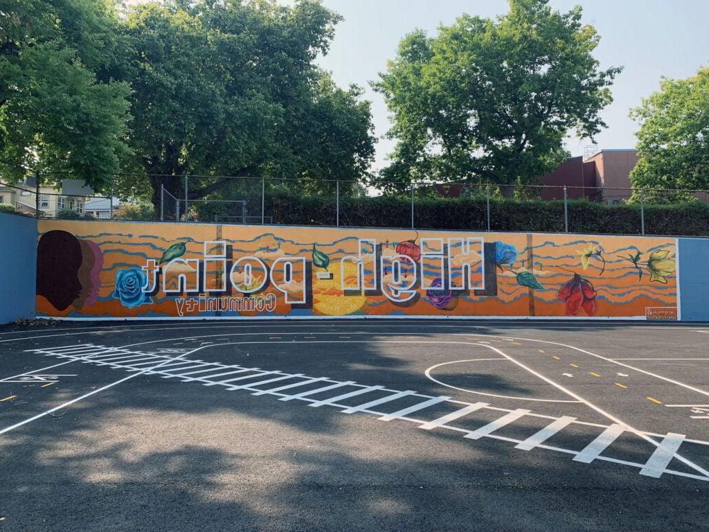 铺砌的游乐区的墙上画着一幅壁画，上面写着“高点社区”